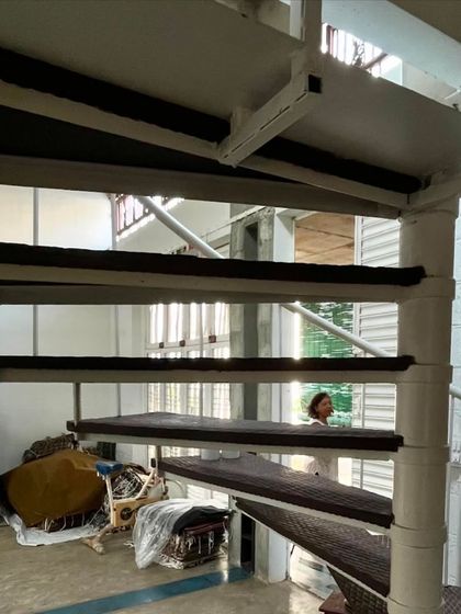 The white spiral staircase in the artist's studio is a light, sculptural element that connects the different levels of the workspace. Its open design allows light and views to filter through, maintaining a sense of spaciousness.