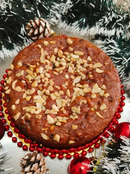 This shot shows my Christmas fruit cake ready for a celebration, surrounded by festive ornaments. I can prepare it in half-kilogram or one-kilogram sizes for your holiday needs.