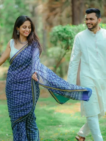 A playful, walking shot in the park. Janhavi's saree flows beautifully as she walks with Umesh, creating a sense of movement and joy.