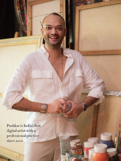 A joyful portrait of digital artist Pushkar Thakur in his studio. His bright smile and the candid nature of the shot, with paint tubes in hand, reveal the passion he has for his work.