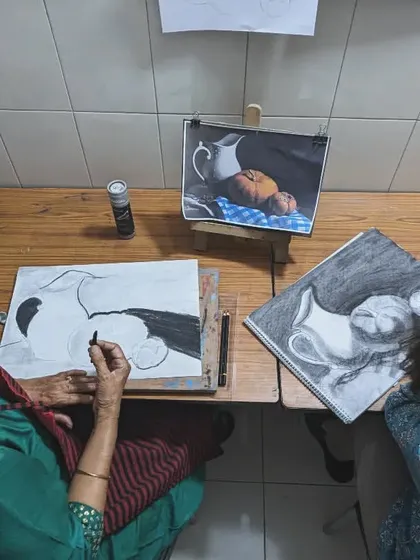 Our adult students, Priyanka and Harinder ma'am, working side-by-side on their charcoal drawings. The studio provides a focused and collaborative atmosphere.