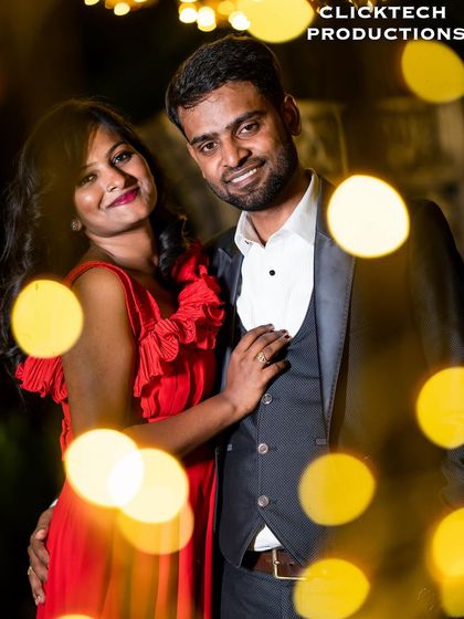 A creative portrait of a couple surrounded by the soft, out-of-focus glow of fairy lights (bokeh), adding a magical and dreamy quality.