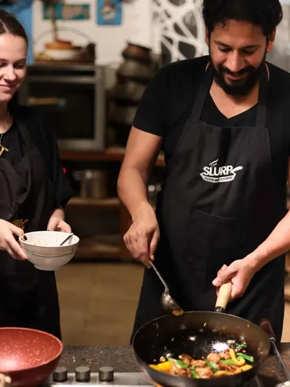 A couple enjoys cooking together during a weekend masterclass. Our studio is a great place to connect with loved ones over a shared passion for food.
