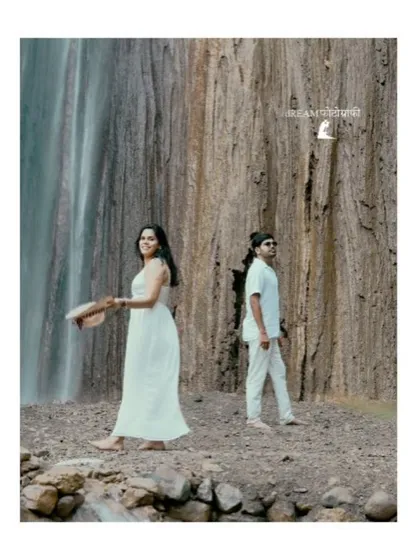 A candid moment by a majestic waterfall in Rishikesh. The natural setting and the couple's relaxed posture create a feeling of peaceful romance.