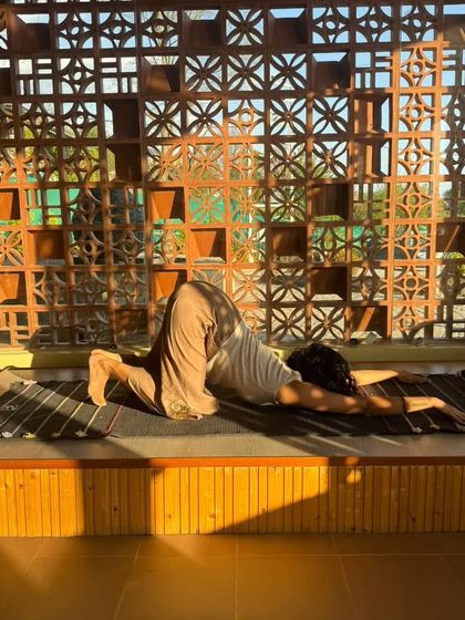 A supported puppy pose to gently open the shoulders and heart space. Using props allows the body to relax completely into the stretch.