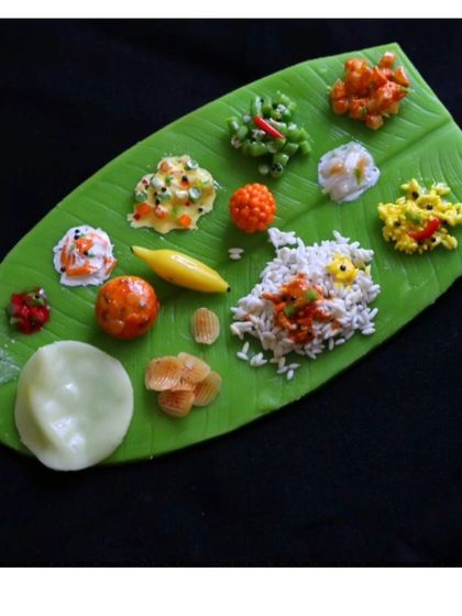 A single, perfect banana leaf meal magnet, showcasing over 15 different handmade food items.