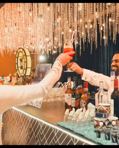 A perfect moment of connection between our bartender and a guest, sharing a toast at an elegant reception. We pride ourselves on creating a friendly and welcoming bar atmosphere.