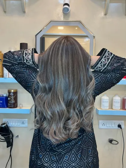 From the back, you can see the full effect of the balayage. The highlights are placed strategically to create a natural, sun-kissed effect with soft, healthy waves.