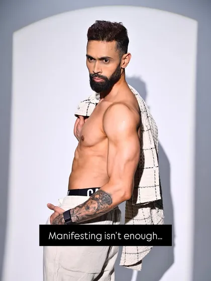 A confident pose with an unbuttoned shirt, captioned "Manifesting isn't enough." This reinforces my philosophy that action is what creates results.