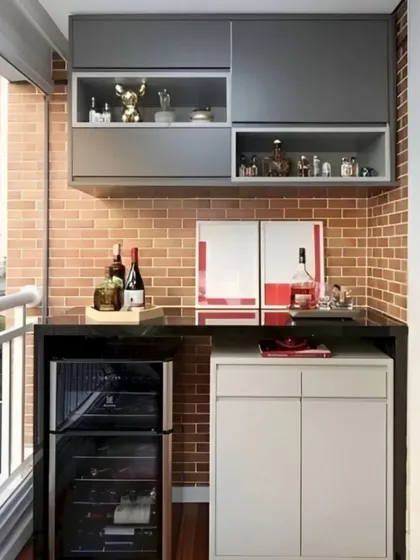A practical design against an exposed brick wall, this bar unit includes a wine fridge, closed cabinets, and overhead storage with display sections. The black countertop provides a durable and stylish surface for serving.