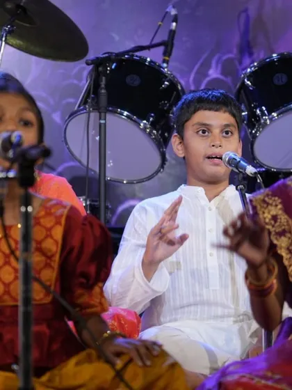 A young student gestures expressively while singing, showing how we teach music as a form of storytelling.