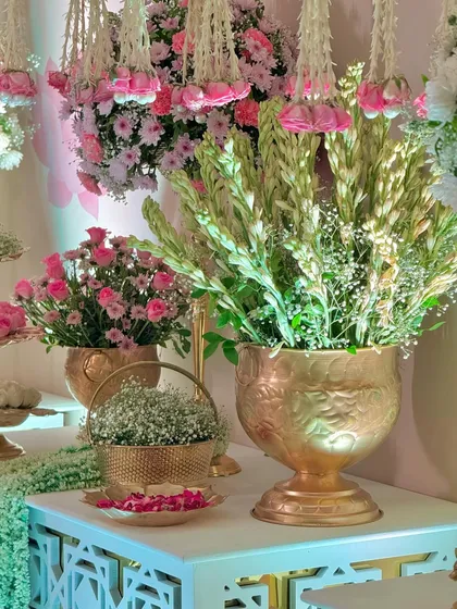 A close-up of the details, where baby's breath and tuberoses are arranged in ornate golden vessels. Every element is chosen to enhance the overall feeling of opulence.