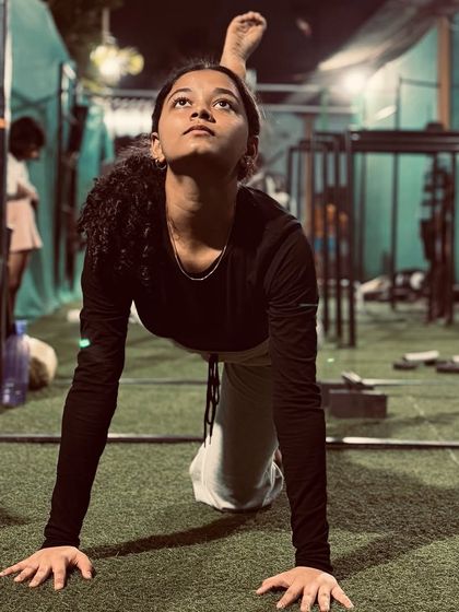 An athlete practices a variation of the cat-cow stretch with a leg extension, a dynamic movement that improves spinal mobility and balance.