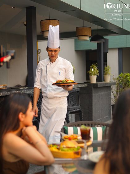 Service with pride. One of our chefs personally presents a freshly prepared dish to guests at our rooftop restaurant.