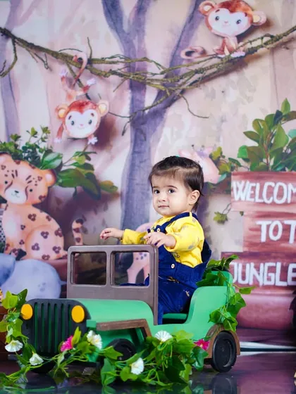 Welcome to the jungle! A little explorer gets ready for an adventure in his mini jeep, surrounded by friendly jungle animals.