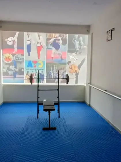 A dedicated area for strength and conditioning, equipped with weights and a bench press.