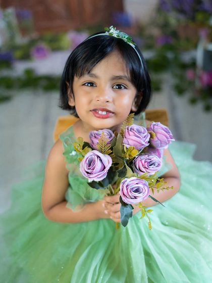 A sweet girl with a bouquet of flowers. Her gentle smile and beautiful green dress make for a lovely and timeless portrait.