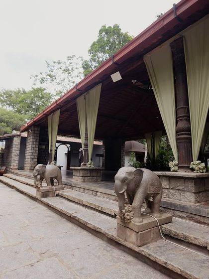 The entrance to the main hall, with stone elephants and simple green drapes, ready for a pastel-themed event.