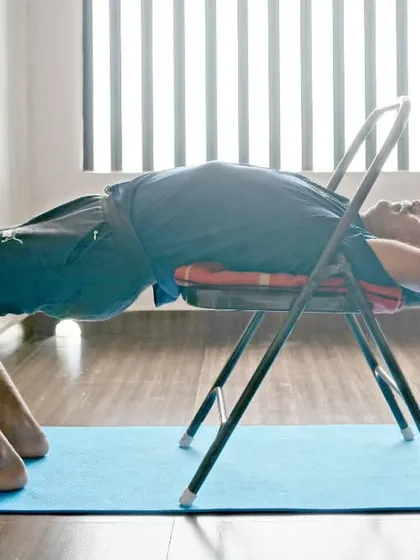 Exploring strength and flexibility with Dwi Pada Viparita Dandasana (Two-Legged Inverted Staff Pose) using a chair for support and stability.
