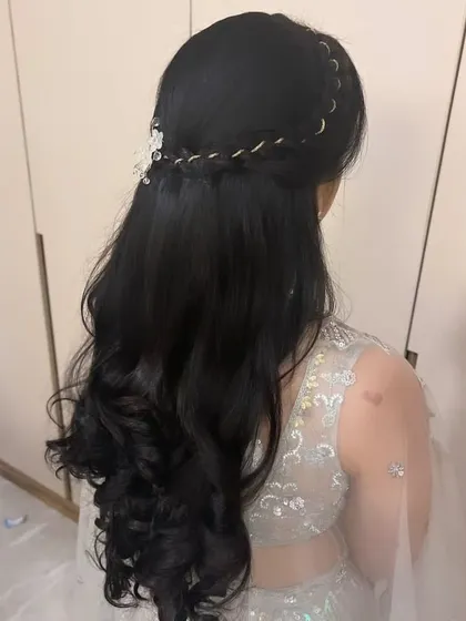 A back view of the hairstyle, showing the placement of the braid and accessory.