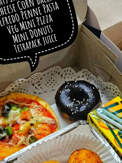 For a hassle-free party, I offer these customized snack boxes. Each one is a treasure chest of goodies, including a mini pizza, cheese corn balls, a mini donut, and juice, ensuring every child gets their own perfect little meal.