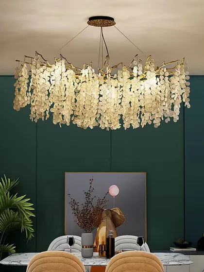 This oval-shaped chandelier with amber glass leaves creates a warm and inviting canopy of light, perfect for a dining space.