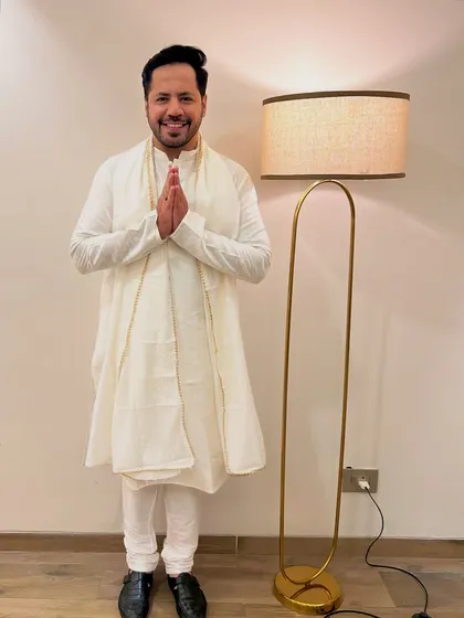 A graceful 'namaste' in a classic white kurta. A look of elegance and respect for a special occasion.