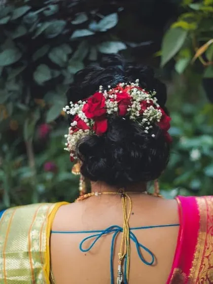 A bridal hairstyle should be a crown. I created this beautiful bun, or 'khopa', and adorned it with fresh red roses and baby's breath, a timeless combination that adds romance and elegance to the overall look.