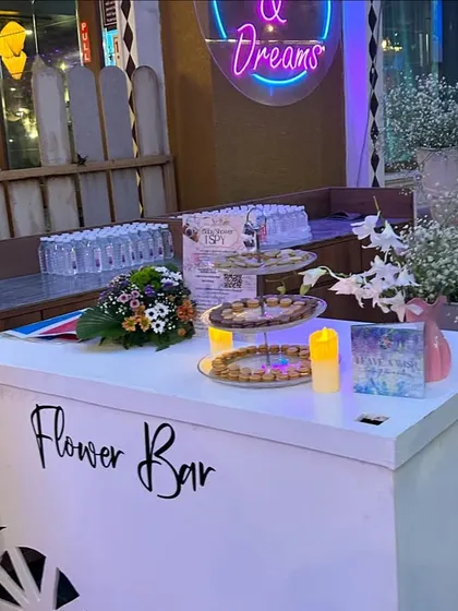 The 'Flower Bar' cart, complete with fresh blooms and a neon sign, was a highlight of the celebration.