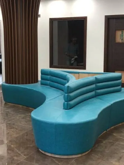 This custom-designed, free-form sofa serves as the centerpiece of the school's reception waiting area. Its unique shape encourages interaction while the teal upholstery adds a vibrant touch to the space.