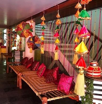 A traditional seating area for a Lohri party, with 'charpai' benches, colourful cushions, and ethnic hangings. We focus on the small details to create an authentic, festive atmosphere.