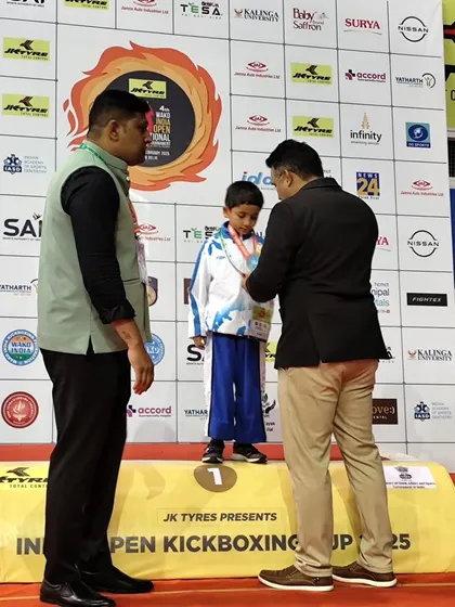 An official places the gold medal around our young champion's neck. These moments of recognition are crucial for building the confidence of our junior athletes.