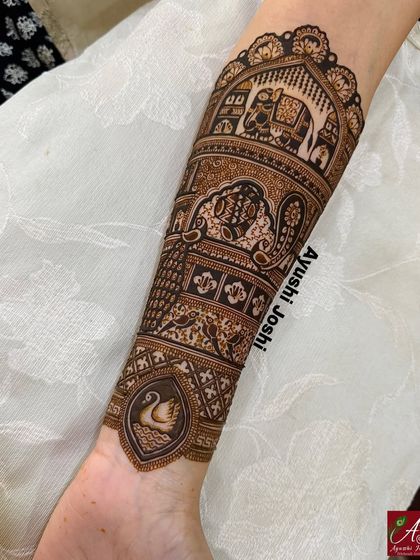 The fully completed armband, showing the majestic elephant, intricate paisleys, and a graceful swan, all brought to life with detailed henna work.