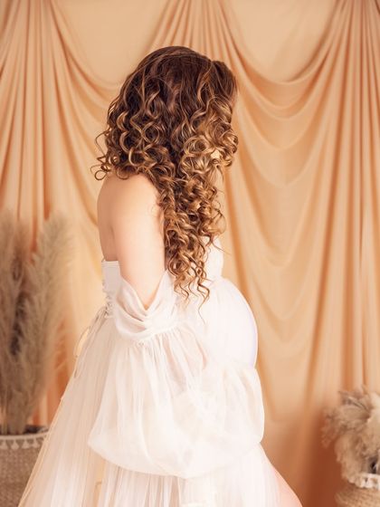 A lovely detail shot focusing on her beautiful curly hair and the soft, romantic feel of the gown.