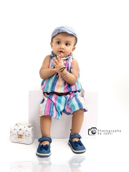 Adding a simple prop like a cap can completely change the feel of a portrait. This photo showcases the versatility of a simple studio setup for baby photography.