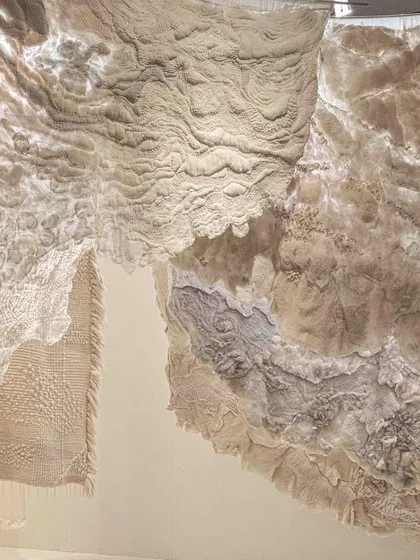 Another view of the 'Sleep Sense' textile installation. The layers of soft, hand-worked fabrics create a cozy, enveloping space that provides a visual antidote to the accelerated pace of modern life.