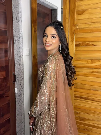 The sister of the groom, looking absolutely stunning for the sangeet night in a beautiful brown embellished lehenga.