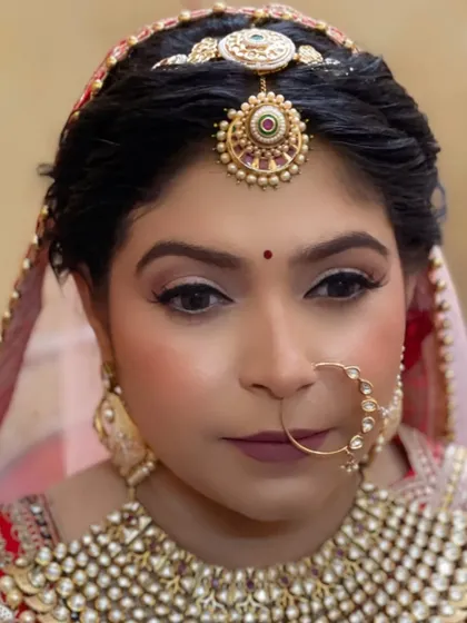 A stunning close-up portrait. The focus is on the bride's captivating eyes and the beautiful details of her matha patti and nath.