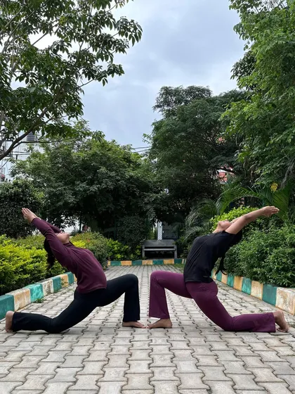 A synchronized Anjaneyasana (Crescent Lunge) with a friend. Practicing together helps align our energies and deepen our connection to the pose.