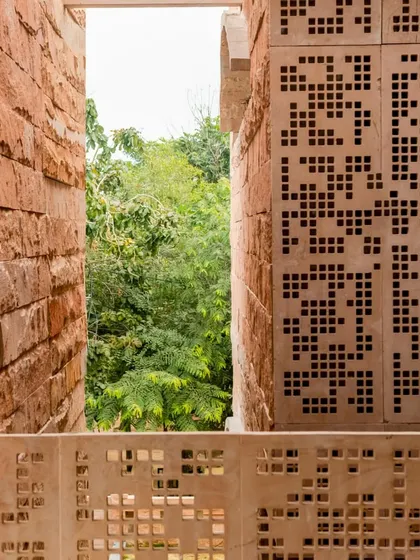 At the House of Solid Stone, narrow fissures between stone walls frame views of the surrounding greenery, drawing on traditional methods to cool the home and connect it to nature.