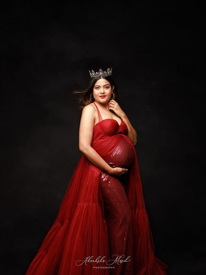 Radiating confidence and glamour in a sequined red gown and crown. This look is for the mother who wants to celebrate her journey with boldness and a touch of royal flair.