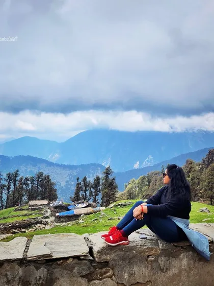 Taking in the breathtaking views of Tungnath. A simple dark sweater, jeans, and bright red shoes make for a comfortable and practical trekking outfit that still looks stylish.
