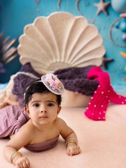 A precious moment from the mermaid-themed shoot, capturing the baby during tummy time on the "sandy" shore.