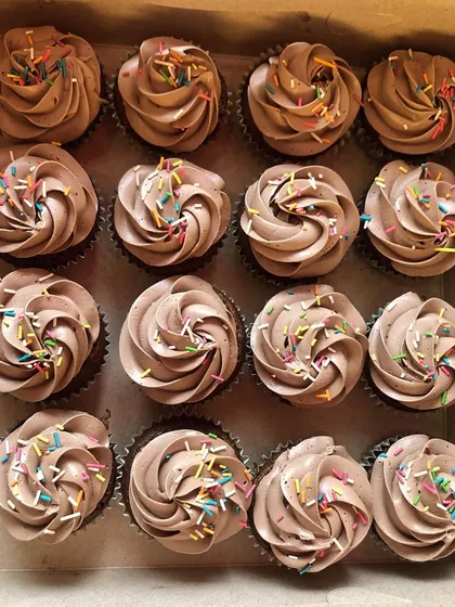 A box of classic chocolate cupcakes with rainbow sprinkles, customized for a classroom birthday celebration. These are a simple, delicious, and fun treat for kids.