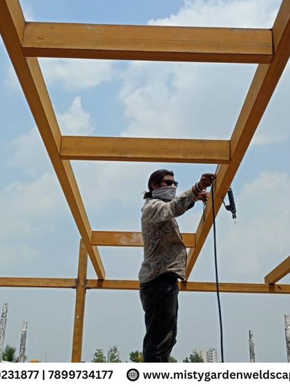 A member of my team working on the high beams of a pergola frame. Safety and precision are key, even when working at heights, to ensure a perfect installation.