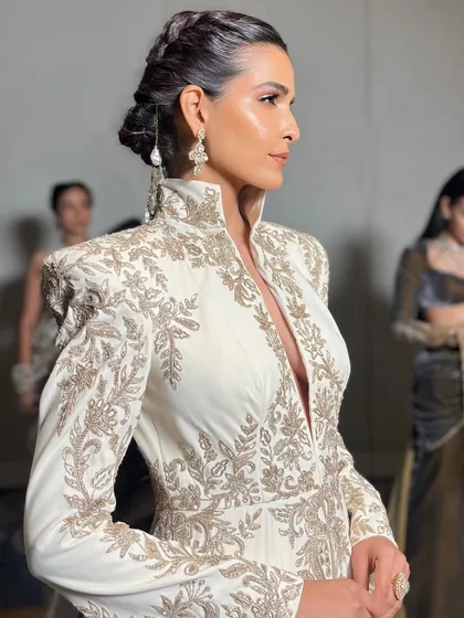 A side profile showcasing the intricate braided hairstyle and the seamless makeup application for the Manish Malhotra runway.