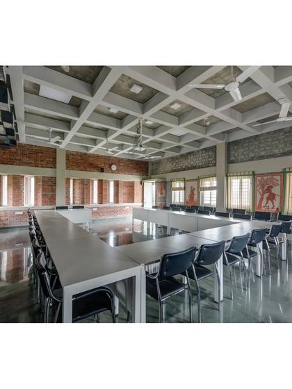 The main conference room at the ASA office, featuring a coffered ceiling and exposed composite block walls. The long windows are designed to provide ample daylight, creating a bright and comfortable meeting space.