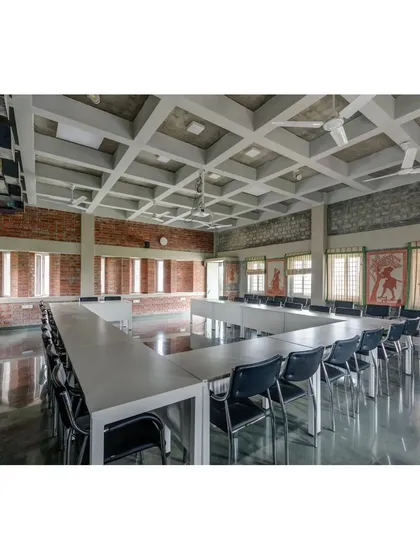 The main conference room at the ASA office, featuring a coffered ceiling and exposed composite block walls. The long windows are designed to provide ample daylight, creating a bright and comfortable meeting space.