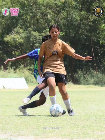 With composure and focus, our player shields the ball from a defender, maintaining possession under pressure.
