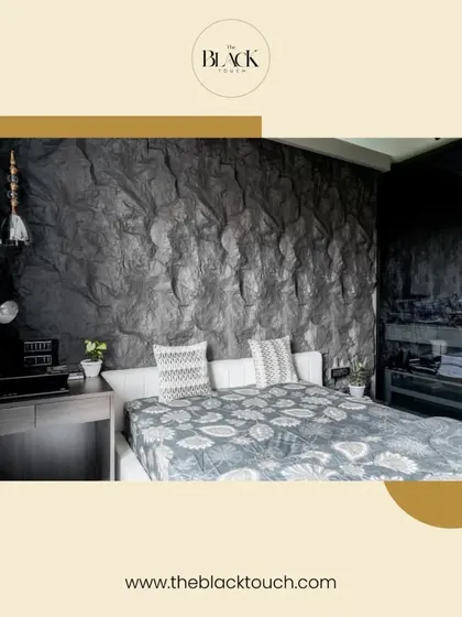 A bold bedroom design featuring a dark, rock-textured accent wall. This dramatic element serves as a stunning backdrop for the minimalist bed, creating a unique and powerful statement.